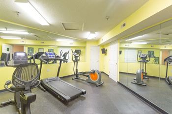 A gym with treadmills, elliptical machines, and other exercise equipment.